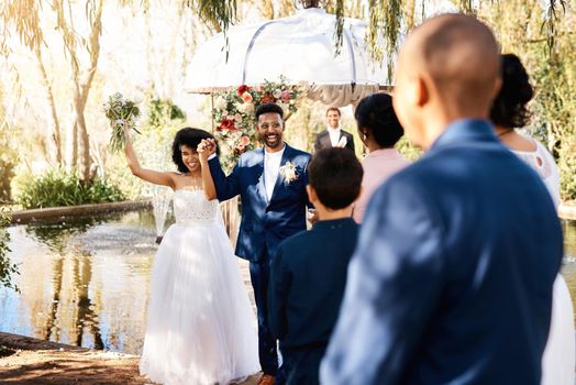 The power of love has brought us all here today. a happy newlywed young couple walking down the aisle in front guests on their wedding day