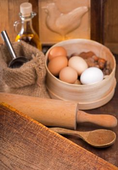 Wooden spoons, spatulas, kitchen utensils on a wooden table. Simple products - flour, butter, nuts and eggs on a wooden table