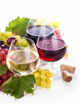 glasses of red and white wine and ripe grapes on table