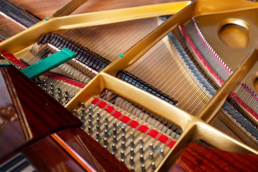 Close-up of the internal string structure of a grand piano, viewed from above. Abstract background, texture. Musical instruments repair concept