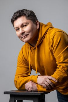 Portrait of proud handsome middle aged Caucasian man looking at camera with satisfied, prideful and egoistic face, wearing urban style hoodie. Indoor studio shot isolated on gray background.
