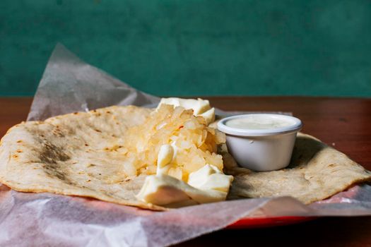 Close up of Nicaraguan Quesillo served on wooden table. Traditional Nicaraguan Quesillo served on wooden table, Traditional Nicaraguan Quesillo served on wooden table with copy space