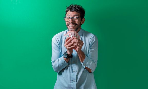 Friendly and happy man with money in his hands looking at the camera, Happy person with money in his hands isolated. Happy person with money in his hands looking at the camera