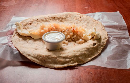 Top view of Nicaraguan Quesillo served on wooden table. Traditional Nicaraguan Quesillo served on wooden table, Close up of Nicaraguan Quesillo served on wooden table