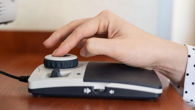 A woman uses a special magnification device for the visually impaired