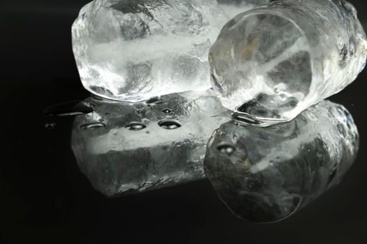 Big Ice cubes and reflections on black background