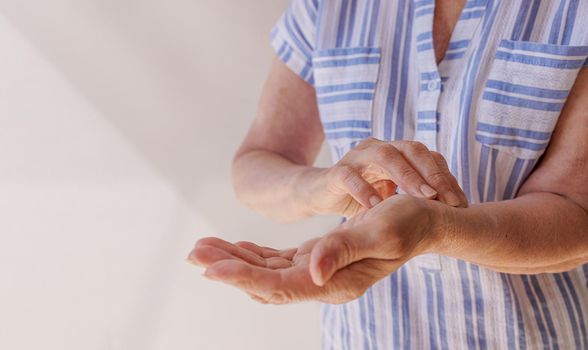 Close-up of an old woman's hands measuring her pulse. The concept of heart disease, coronary disease, high or low blood pressure. The medicine. Home conditions