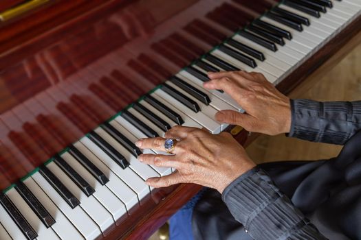 Close-up, hands of an old woman playing the piano