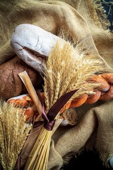 Top view of a bouquet of wheat lying on fresh bread and other bakery products as a symbol of food and agrarian well-being of the country.