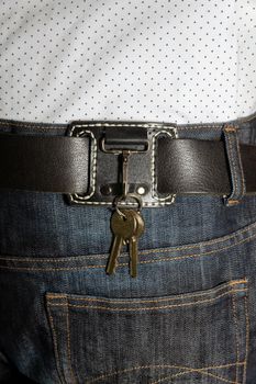 leather key strap with iron carabiner with two keys mounted on a leather belt.