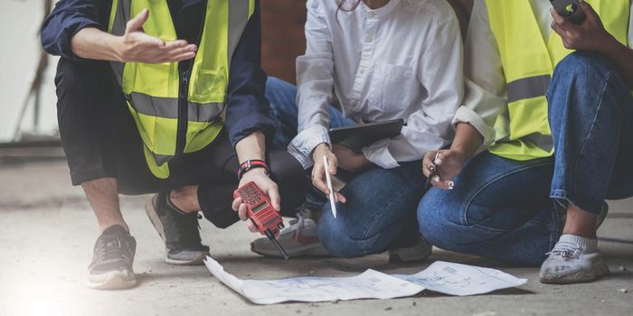 Professional Construction and Engineer team Working on workplace. Professional black architect and construction worker working look at blueprint plan on site..