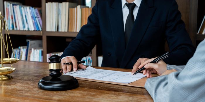 Business people negotiating a contract. Human hands working with documents at desk and signing contract.