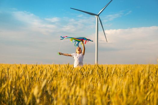 Happy Little girl running in a wheat field with a kite in the summer. Well-planned and active weekend. Happy childhood.