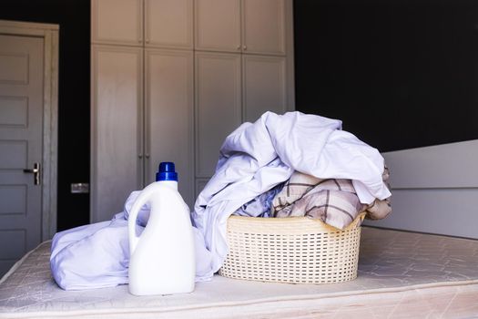 Close-up, mockup white large bottle with detergent liquid for washing or bleaching bed linen. The concept of products for the care and washing of sheets, blankets and other things