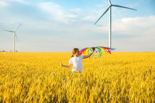 Happy Little girl running in a wheat field with a kite in the summer. Well-planned and active weekend. Happy childhood.