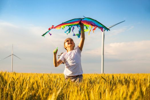 Happy Little girl running in a wheat field with a kite in the summer. Well-planned and active weekend. Happy childhood.