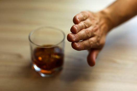 Hands lock chain a glass of whiskey To stop drinking. Alcoholism concept. Stop alcohol addiction. Addicting to alcoholic drink.