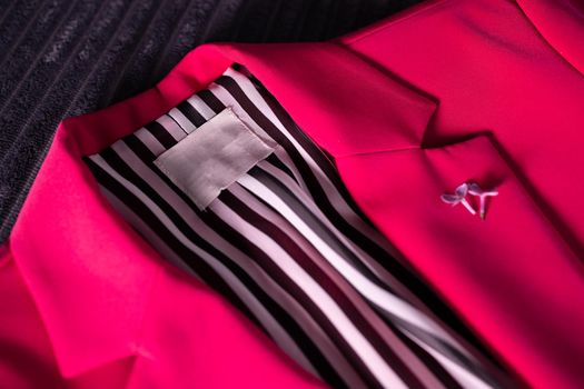 Close-up, bright pink jacket with an empty label. Mockup for company logo, lettering, brand name. stylish outerwear. striped lining.