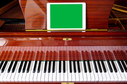 Close-up, on the piano a sign with an empty space, copy space, copy paste. Chroma key green. Cover concept for music festival, concert. Tutorial for musicians online
