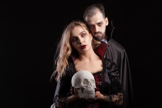 Romantic and imortal vampire couple looking into the camera for halloween carnival.