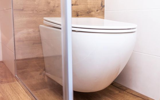 Modern bathroom interior. Close-up of a white toilet bowl, hanging structure for a small room. The concept of modern plumbing, interior design, hotel.