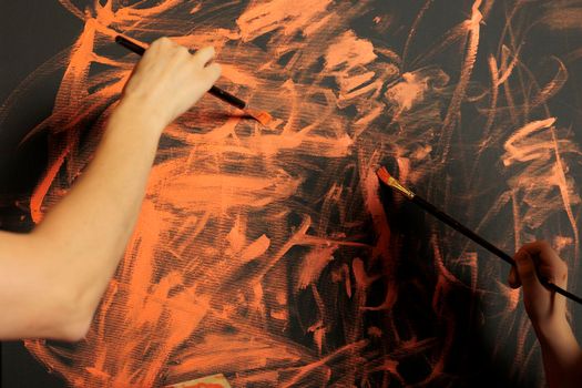 People painting canvas creation with orange color, using watercolor aquarelle paint and paintbrush. Creating artwork design with creative skills and artistic tools, colormix and palette. Close up.