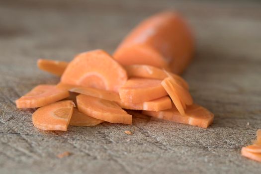 Close up of slices of carrot on cutting board.