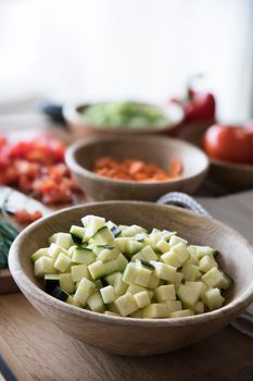 Bowl of zucchini cubes in wooden bowl , vertical orientation with copy space.