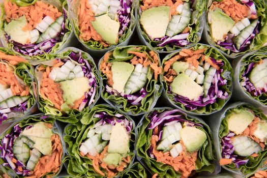 Vegetarian spring rolls with avocado, carrots, cucumber and red cabbage.