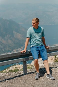 Man tourist enjoys the view of Kotor. Montenegro. Bay of Kotor, Gulf of Kotor, Boka Kotorska and walled old city. Travel to Montenegro concept. Fortifications of Kotor is on UNESCO World Heritage