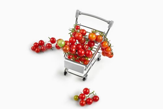 Shopping trolley full of tomatoes on white background. Top view with copy space