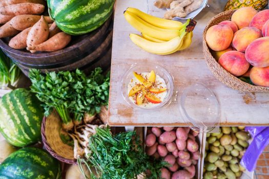 Healthy fruit shake on table with lot of fruits and vegetables in store.