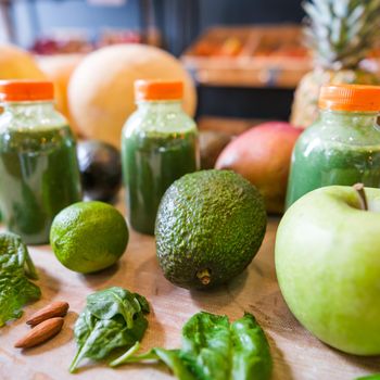 Healthy fruit shake on table with fruits and vegetables ingredients around.