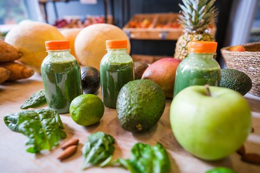 Healthy fruit shake on table with fruits and vegetables ingredients around.