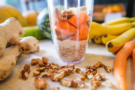 Healthy fruit shake on table with fruits and vegetables ingredients around.