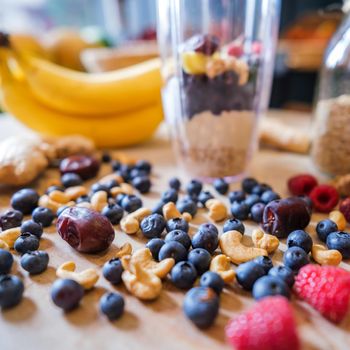 Healthy fruit shake on table with fruits and vegetables ingredients around.