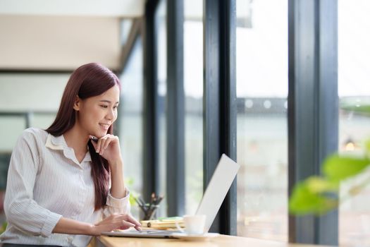 Portrait of a business woman using a computer to work on financial statements.