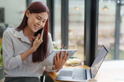 Asian businesswoman using the phone to contact a business partner.