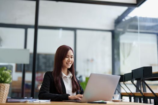 Portrait of a business woman using a computer to work on financial statements.