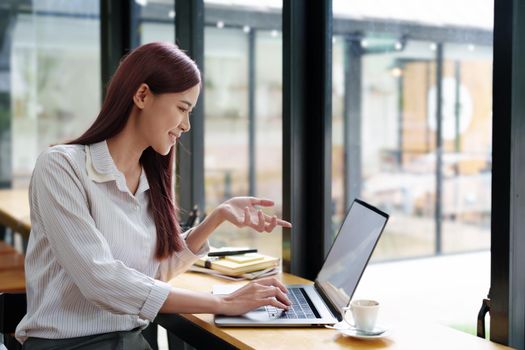 Portrait of a business woman using a computer to work on financial statements.