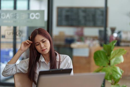 Portrait of a businesswoman holding documents and using computers to analyze budget work and make marketing plans to meet the needs of office clients.