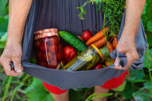 Senior woman preserving vegetables in jars. Selective focus. Food.