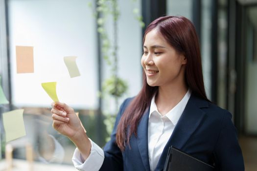 Portrait of an Asian businesswoman working at the office Grab a notepad to make a marketing plan.