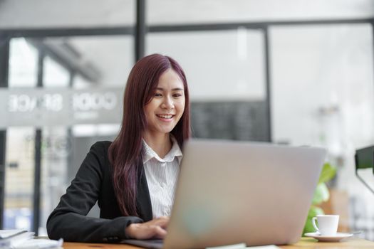 Portrait of a business woman using a computer to work on financial statements.