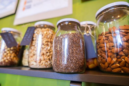 Close up image of jars with chia and other seeds in vegan food shop.