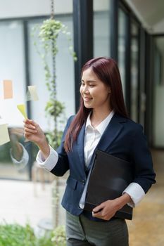 Portrait of an Asian businesswoman working at the office Grab a notepad to make a marketing plan.