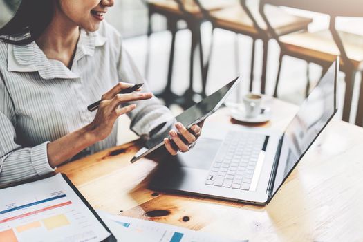 Portrait of an Asian female employee using a tablet computer to work to gather information and analyze marketing plans and investment budgets to increase company profits.