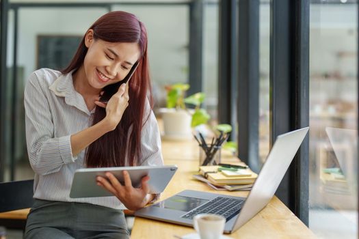 Asian businesswoman using the phone to contact a business partner.