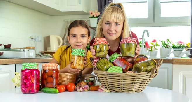 Woman with jar preserved vegetables for winter mother and daughter. Selective focus. Food.