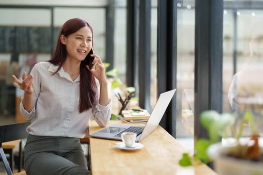 Asian businesswoman using the phone to contact a business partner.